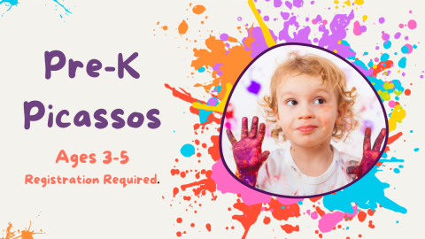 Toddler with hands painted purple surrounded by paint splatters.